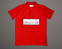 Load image into Gallery viewer, Red polo shirt with white patch, black outlining, and red logo.